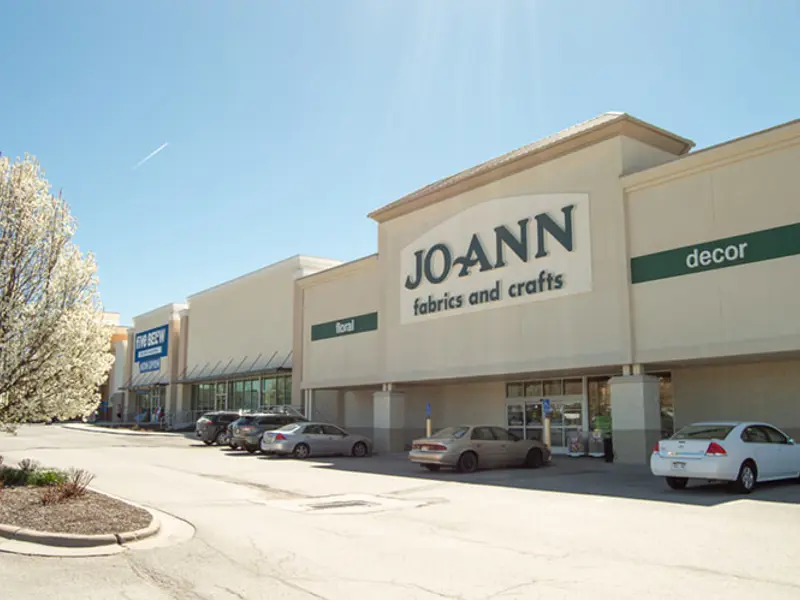 Exterior of front of multiple buildings and parking area apart of Wolf Creek Plaza