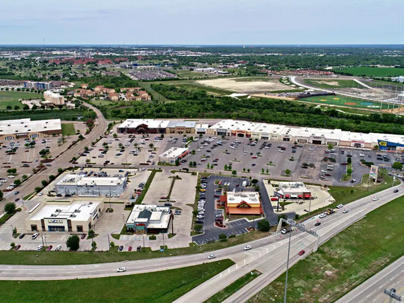 Exterior aerial view of parking area and multiple businesses within Central Texas Marketplace