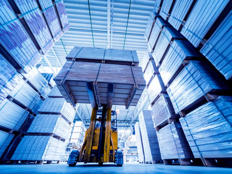 Interior of forklift within shipping facility moving a large pallet