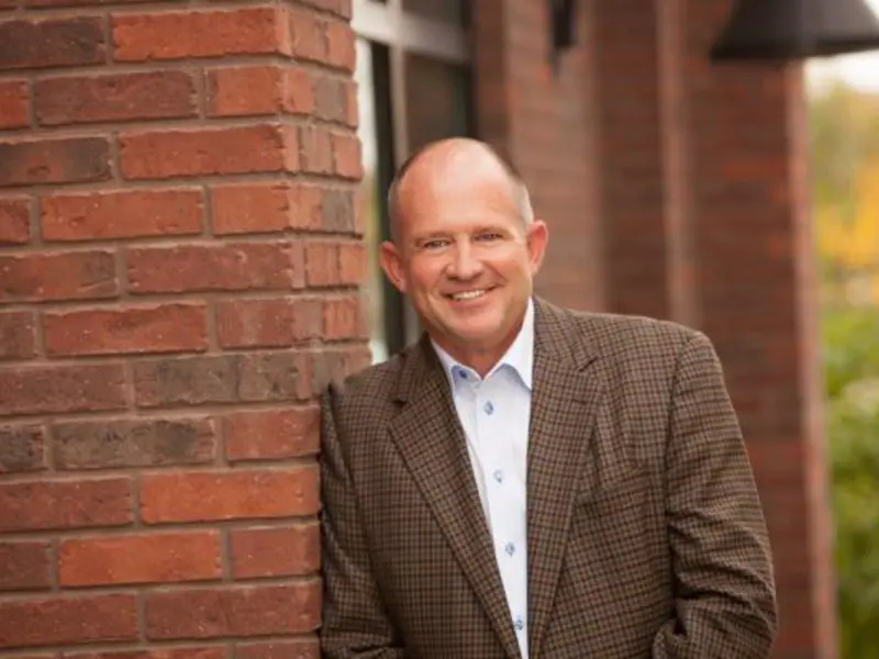 Headshot of former Ball Ventures CEO Cortney Liddiard against red brick wall