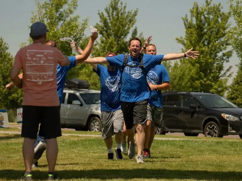 Group of male runners celebrating on grassy field