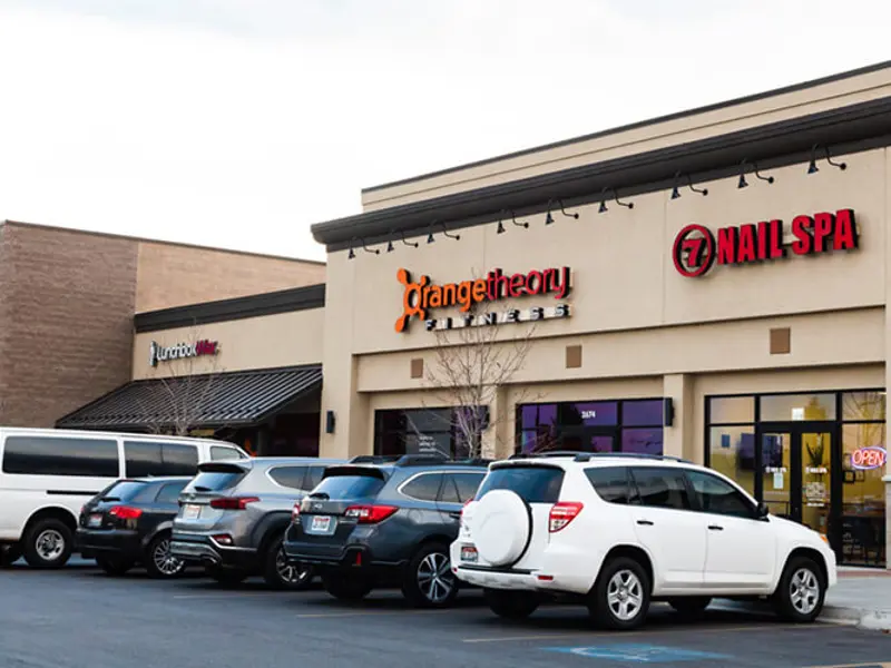 Exterior of front of multiple buildings and cars at Sandcreek Commons