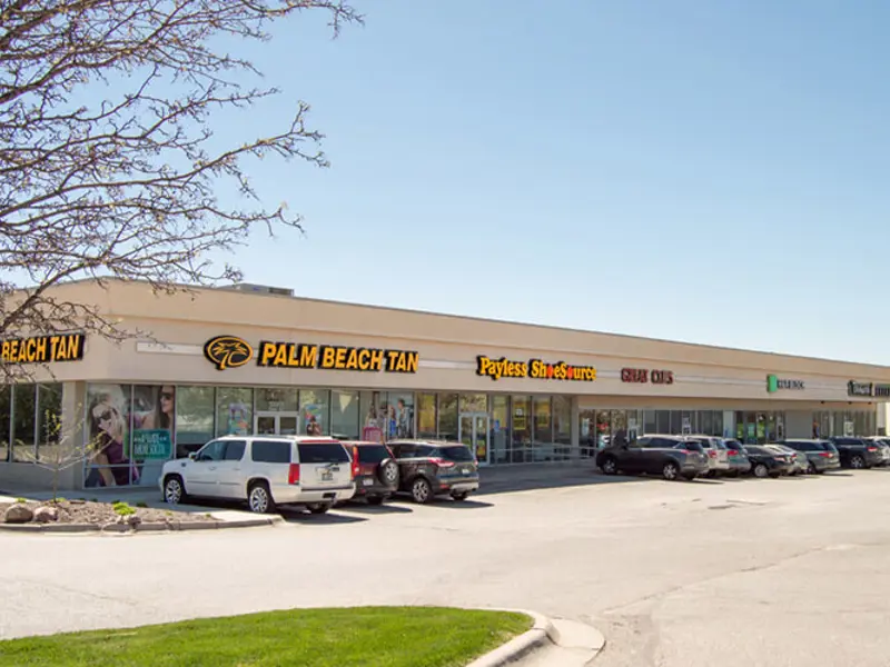 Exterior of front of multiple buildings and parking area apart of Wolf Creek Plaza