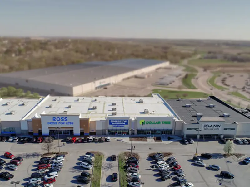 Exterior aerial view of front of multiple buildings and parking area apart of Wolf Creek Plaza