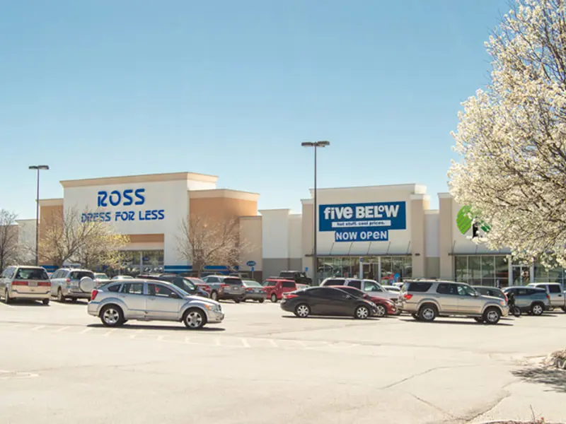 Exterior of front of multiple buildings and parking area apart of Wolf Creek Plaza