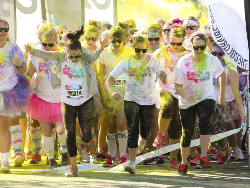 Multiple runners with powdered color running in a race