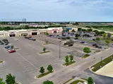Exterior aerial view of multiple buildings and parking areas apart of Central Texas Marketplace