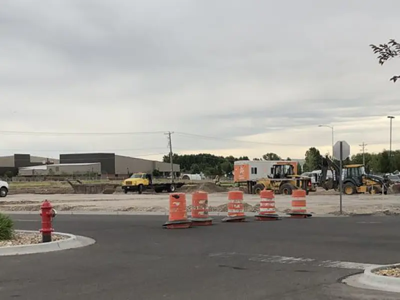 Exterior of asphalt parking lot with construction cones on cloudy day
