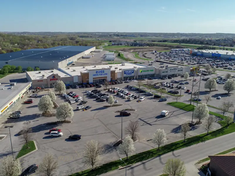 Exterior aerial view of front of multiple buildings and parking area apart of Wolf Creek Plaza