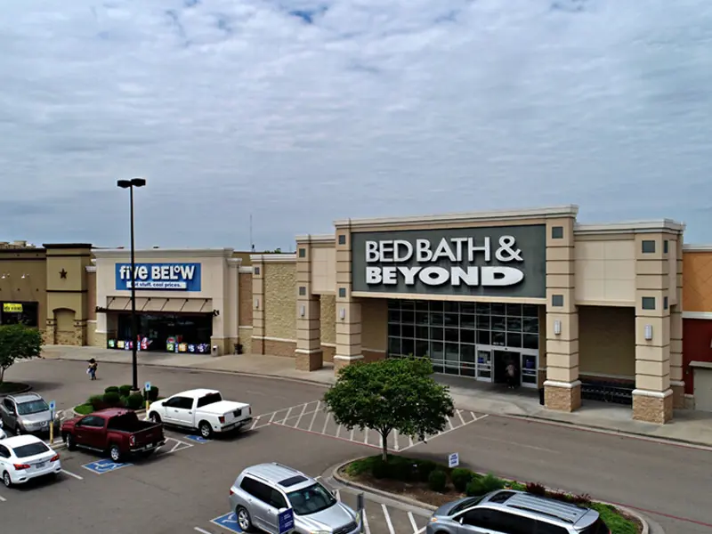 Exterior aerial view of multiple buildings and parking areas apart of Central Texas Marketplace