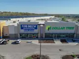 Exterior aerial view of front of Dollar Tree, buildings and parking area apart of Wolf Creek Plaza