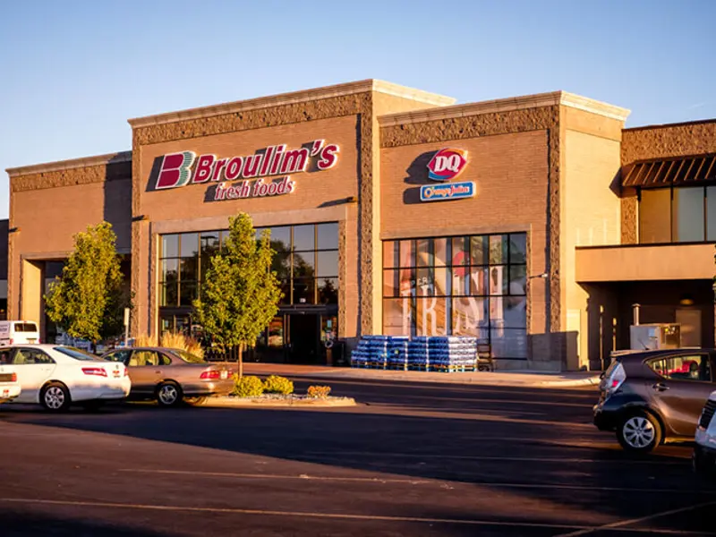 Exterior of front of Broulims building and cars at Sandcreek Commons