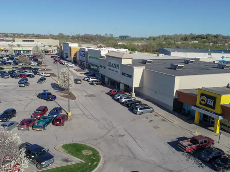 Exterior aerial view of front of multiple buildings and parking area apart of Wolf Creek Plaza
