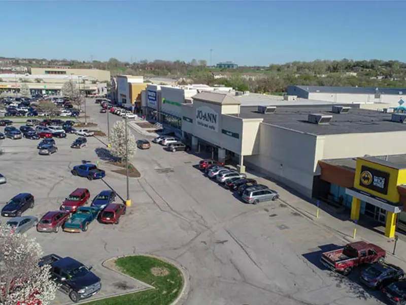 Exterior aerial view of front of multiple buildings and parking area apart of Wolf Creek Plaza