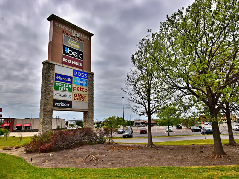 Exterior of multiple business signs on grassy road-facing area