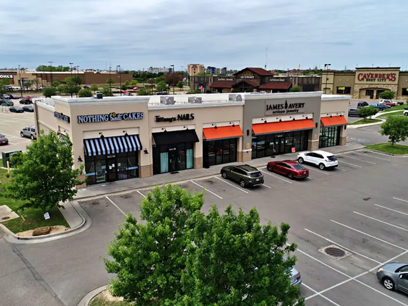 Exterior aerial view of multiple buildings and parking areas apart of Central Texas Marketplace