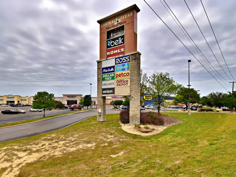 Exterior of multiple business signs on grassy road-facing area